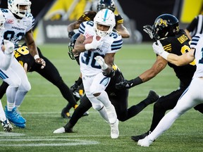 Toronto Argonauts running back Martese Jackson (30) slips past some Hamilton Tiger-Cats tackles while returning a punt for a touchdown during first-half CFL Football action in Hamilton, Ont. on Saturday, September 30, 2017. THE CANADIAN PRESS/Peter Power