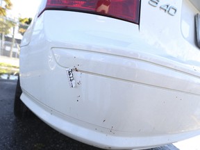 A Toronto Police crime scene marker is seen on a Volvo bumper covered in blood spatter in the parking lot next to Rebel nightclub after two men were fatally shot Sunday, October 1, 2017. (Jack Boland/Toronto Sun)