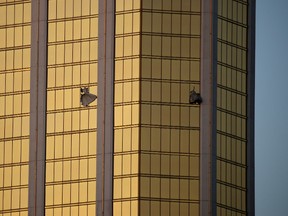 Drapes billow out of broken windows at the Mandalay Bay resort and casino Monday, Oct. 2, 2017, on the Las Vegas Strip following a deadly shooting at a music festival in Las Vegas. A gunman was found dead inside a hotel room. (AP Photo/John Locher)