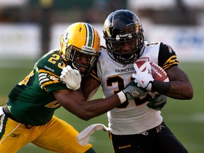 Edmonton Eskimos Marcell Young #23 tackles Hamilton Tiger-Cats C.J. Gable #32 during first half action on August 2, 2013, at Commonwealth Stadium in Edmonton.