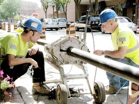 Workmen – Mike Clark (left) and Al Morin of Henry Heynink Construction – from this 2010 photo were installing a temporary waterline in downtown Chatham. The Public Utilities Commission last week announced it will be lowering the interest rate it charges to property owners that finance local improvements for new water and sewer infrastructure.