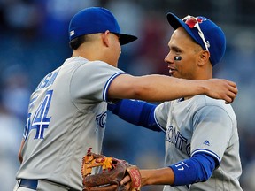 Ryan Goins of the Toronto Blue Jays hugs teammate Roberto Osuna after defeating the New York Yankees at Yankee Stadium on Oct. 1, 2017. (Adam Hunger/Getty Images)