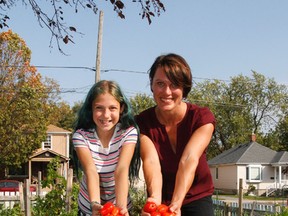 Sarah Keyes, Food Skills Program manager with Loving Spoonful and Grade 6 student Nora Bell-Smith show off some ripe tomatoes on Wednesday that were grown in the Rideau Public School Grow Garden in Kingston this summer as part of the Loving Spoonful Grow Project. (Julia McKay/The Whig-Standard)