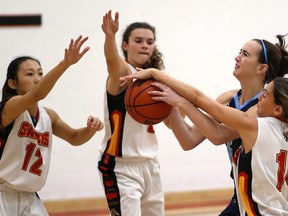 Lucas' Emma Fischer runs into a lot of hands as she tries to drive against Chloe Shum, Kailey Ballantyne and is blocked by Diana Jonuzi of Saunders during their game at Saunders on Monday October 2, 2017.  (MIKE HENSEN, The London Free Press)