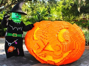 This 2015 image shows a giant pumpkin made from Legos at Legoland in Winter Haven, Fla., with a costumed greeter standing nearby. The costumed witch and giant Lego pumpkin are also part of the 2017 Brick or Treat event at Legoland. (Legoland Florida Resort via AP)
