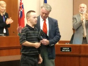 Cody Daye receives a Sarnia Accessibility Award from Mayor Mike Bradley in council chambers Monday. Daye was one of eight award recipients this year. (Tyler Kula/Sarnia Observer/Postmedia Network)