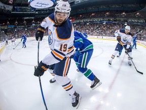 Edmonton Oilers' Patrick Maroon looks for the puck in the corner while being checked by Vancouver Canucks' Troy Stecher during the first period of a pre-season NHL hockey game in Vancouver on Sept. 30, 2017. (THE CANADIAN PRESS/Darryl Dyck)