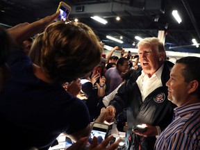 People take photos with President Donald Trump as he visits a disaster relief distribution center at Calgary Chapel in Guaynabo, Puerto Rico, Tuesday, Oct. 3, 2017. Trump is visiting Puerto Rico in the wake of Hurricane Maria. (AP Photo/Evan Vucci)