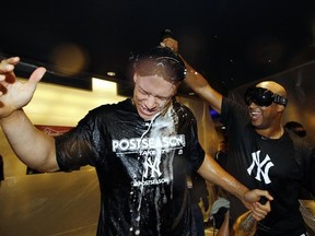 New York Yankees outfielder Aaron Hicks, right, pours sparkling wine over teammate Aaron Judge after they defeated the Minnesota Twins in the American League wild-card playoff game in New York. (AP Photo/Kathy Willens)