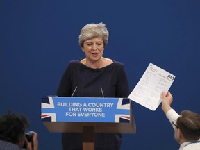 Comedian Simon Brodkin, also known as Lee Nelson confronts British Prime Minister Theresa May during her keynote speech, during the Conservative Party Conference at the Manchester Central Convention Complex in Manchester, England, Wednesday Oct. 4, 2017. (Peter Byrne/PA via AP)