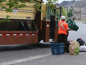 A worker collects items from blue boxes and green bins in Ajax, Ont. on June 5, 2015. (Veronica Henri/Toronto Sun)