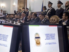 Computer images with writing, which is part of a wire-tapping, reading in Italian "The world is like this Ava... it was born corrupted and it will die corrupted, no one can fix the world..." during a police press conference on an organized crime operation, in Rome, Wednesday, Oct. 4, 2017.  (Massimo Percossi/ANSA via AP)