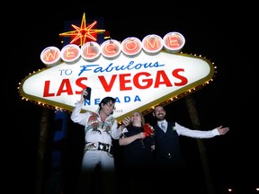 In this Tuesday, Oct. 3, 2017 photo, Elvis tribute artist Eddie Powers poses for a photo with newlyweds Rob and Kelly Roznowski after he married them at the Welcome to Las Vegas sign in Las Vegas. (AP Photo/Chris Carlson)