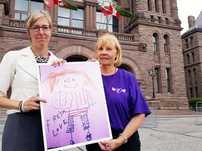 Rally organizer Alysson Storey is shown with Freya Payne?s grandmother, Marjorie Payne, at Queen?s Park in Toronto Wednesday. Freya drew this picture of Pippi Longstocking in May. The five year old died along with her mother, Sarah Payne, in a crossover crash on Highway 401 near Dutton, prompting a renewed push for median barriers. (TREVOR TERFLOTH, The Daily News)