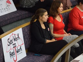 Allison Preyde, left, Holly Taylor, and Kelsey Adams from Anova watch the debate over the bylaw licensing the adult live entertainment industry at London City Hall on Wednesday. (MORRIS LAMONT, The London Free Press)