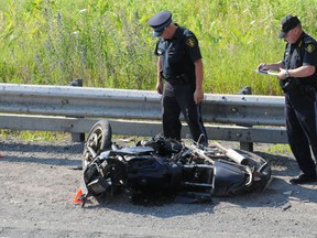 OPP officers look at a motorcycle on the side of Highway 401 following a fatal crash in this file photo.