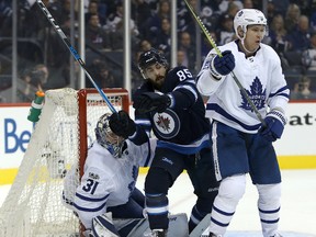 Forward Mathieu Perreault of the Winnipeg Jets fights past defenceman Nikita Zaitsev and goaltender Frederik Andersen of the Toronto Maple Leafs during NHL action on Oct. 4, 2017 at Bell MTS Place. (Jason Halstead /Getty Images)