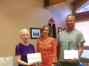 Shannon LaHay, AMGH Foundation Coordinator (c) presents winners Jean Imanse (l) and Bob Orr (r) with their new iPads.