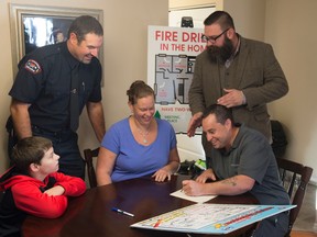 Martin Landry, Fire Prevention officer with  Edmonton Fire Rescue Services  oined at the St. Pierre family and Minister of Municipal Affairs Shaye Anderson as they planned and practised their fire escape plan and demonstrate the importance of having a second way out on October 4, 2017.  Photo by Shaughn Butts / Postmedia