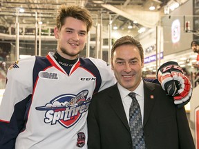 Windsor Spitfires centre Logan Brown checks in with his dad, 67's head coach Jeff Brown, prior to the OHL game at TD Place Arena on Jan. 9, 2015. (Wayne Cuddington/Postmedia)