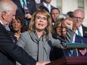 Former Rep. Gabby Giffords of Arizona who survived an assassination attempt in 2011, flanked by Rep. Mike Thompson, D-Calif., left, and Rep. John Lewis, D-Ga., right, joins House Democrats in a call for action on gun safety legislation on the House steps Wednesday morning after the deadly mass shooting in Las Vegas this week, at the Capitol in Washington, Wednesday, Oct. 4, 2017. (AP Photo/J. Scott Applewhite)