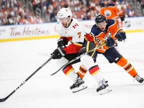 Kailer Yamamoto #56 of the Edmonton Oilers, playing in his first NHL game, skates against T.J. Brodie #7 of the Calgary Flames at Rogers Place on October 4, 2017 in Edmonton, Canada.