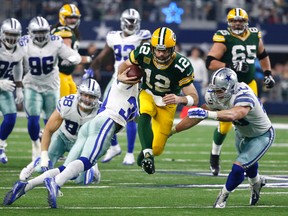 In this Jan. 15, 2017, file photo, Green Bay Packers quarterback Aaron Rodgers rushes for a gain as Dallas Cowboys' Sean Lee and Anthony Brown defend during NFL divisional playoff game in Arlington, Texas. (AP Photo/Michael Ainsworth, File)