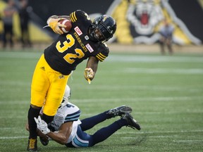 Hamilton Tiger-Cats running back C.J. Gable (32) is tackled by Toronto Argonauts defensive back Brandon Harris (4) during first half CFL football action in Hamilton, Ont., on Monday, September 4, 2017.