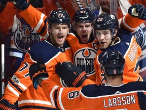 Edmonton Oilers Connor McDavid (97) celebrates with Oscar Klefbom (77) and Leon Draisaitl (29) his first goal of the game against the Calgary Flames during the season opener of NHL action at Rogers Place in Edmonton, October 4, 2017.