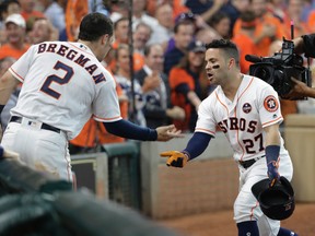 Houston Astros' Jose Altuve (27) celebrates his solo home run, his third of the game, against the Boston Red Sox with teammate Alex Bregman (2) in the seventh inning in Game 1 of baseball's American League Division Series, Thursday, Oct. 5, 2017, in Houston. (AP Photo/David J. Phillip)