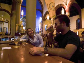 In this Aug. 7, 2017 photo, Jesse Hulien, right, drinks a beer as Molly Hartman, left, looks on, at the Church Brew Works, a former church renovated into a brewery, in Pittsburgh. Breweries opening in renovated churches are winning fans but earning disapproval from clergy and worshippers across the U.S. (AP Photo/Dake Kang)