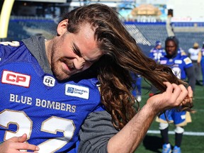 Winnipeg Blue Bombers fullback John Rush takes his hair out of a man-bun after practice on Thurs., Oct. 5, 2017. Rush has been letting his hair grow for three years, and will cut it when he reaches $10,000 raised for breast cancer research. Kevin King/Winnipeg Sun