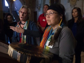 Surrounded by Chief Marcia Brown Martel and Sixties Scoop survivors, Crown-Indigenous Relations and Rorthern Affairs Minister Carolyn Bennett responds to a question during a news conference on Parliament Hill, in Ottawa on Friday, October 6, 2017. Bennett announced a compensation package for indigenous victims of the sixties scoop. THE CANADIAN PRESS/Adrian Wyld
