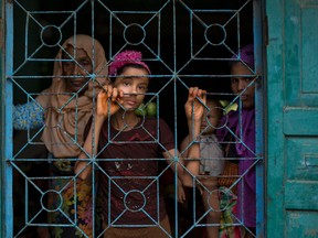 In this Monday, Oct. 2, 2017, file photo, newly arrived Rohingya Muslims from Myanmar look out from a madrasa window that they used as a shelter in Shahparirdwip, Bangladesh. AP Photo/Gemunu Amarasinghe, File