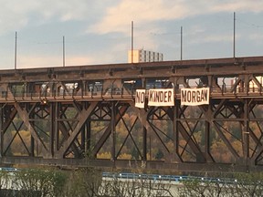 Activists dropped a 50-foot-wide banner from the High Level Bridge in Edmonton Friday morning to protest a proposed pipeline expansion through British Columbia.