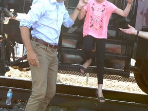 Prime Minister Justin Trudeau helps his daughter Ella-Grace off the train as they prepare to depart following a stop in Calgary for the CP Canada 150 train Sunday, July 30, 2017. (Jim Wells/Postmedia)