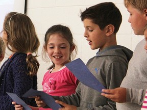 Grade 3 Errol Village student Rebecca Walker listens as Ashe Felton, Grade 4, reads an excerpt from "Only One You" by Linda Kranz. The book reading was part of a dedication ceremony for the Nancy Swanstrom Learning Commons Friday, honouring the school's former principal who was killed in 2015. (Tyler Kula/Sarnia Observer)