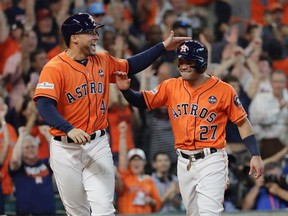 Astros' George Springer (left) and Jose Altuve (right) celebrate after they scored on teammate Carlos Correa's double in Game 2 of the American League Division Series against the Red Sox in Houston on Friday, Oct. 6, 2017. (David J. Phillip/AP Photo)