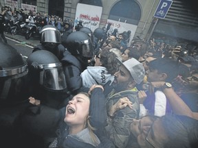 A girl grimaces as Spanish national police push away pro-referendum supporters outside a school assigned to be a polling station by the Catalan government in Barcelona, Spain, during Sunday?s voting. (Emilio Morenatti/AP file photo)