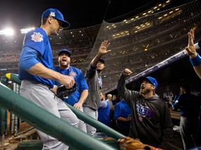 Cubs starting pitcher Kyle Hendricks (left) is greeted by teammates in the dugout at the end of the seventh inning in Game 1 of the National League Division Series against the Nationals at Nationals Park in Washington on Friday, Oct. 6, 2017. (Pablo Martinez Monsivais/AP Photo)