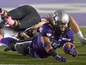 Western Mustangs running back Yannick Harou is tripped up by Carleton lineman Elijah Watson during the first quarter of an OUA game at TD Stadium on Friday October 6, 2017 (MORRIS LAMONT, The London Free Press)