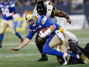Blue Bombers quarterback Matt Nichols (15) gets sacked by Tiger-Cats' Davon Coleman (0) during first half CFL action in Winnipeg on Friday, Oct. 6, 2017. (John Woods/The Canadian Press)