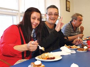 John Lappa/Sudbury Star/Postmedia Network
Eileen John and her cousin, Buck Liepins, enjoy a meal at the Blue Door Soup Kitchen Thanksgiving feast in Sudbury on Friday. More than 200 people enjoyed a hot turkey meal and pumpkin pie.
