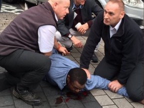 A man is held down after a car was driven into pedestrians outside a London Museum Saturday. (Twitter photo)