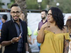 In this Tuesday, Oct. 3, 2017 photo, Pulse shooting survivor Angel Colon, left, talks with friend Melissa Cruz during a vigil in Orlando, Fla. (AP Photo/John Raoux)