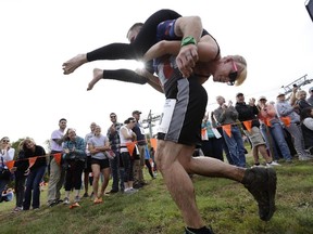 In this Oct. 8, 2016 file photo, Jaime Devine is carried by her husband, Thomas Devine, of Boston, Mass., during the North American Wife Carrying Championship at the Sunday River Ski Resort in Newry, Maine. (AP Photo/Robert F. Bukaty, File)