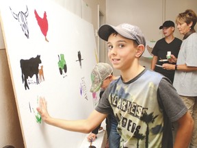 Milo and area residents made a mural last Friday at the village’s skating rink in celebration of the 10th anniversary of Alberta Culture Days and Canada’s 150th anniversary. This mural will soon be installed onto the outside of the Village of Milo’s new office, the former Scotiabank building. Here, Dallin Bertschy, 10, from Milo, leaves his hand print on the mural underneath the photo he painted of a cow and calf.
