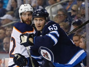 Edmonton Oilers' Eric Gryba (62) and Winnipeg Jets' Mark Scheifele (55) watch the puck during second period NHL pre-season game action in Winnipeg on Wednesday, September 20, 2017. THE CANADIAN PRESS/John Woods