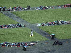 A member of the FBI walks among piles of personal items at the scene of a mass shooting Friday, Oct. 6, 2017, in Las Vegas. (AP Photo/John Locher)