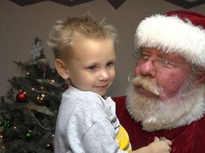In this Sept. 10, 2017 photo from video provided by WIBW-TV in Topeka, Kan., three-year-old Christian Risner sits on Santa's lap in Lebo, Kan.  (WIBW-TV via AP)